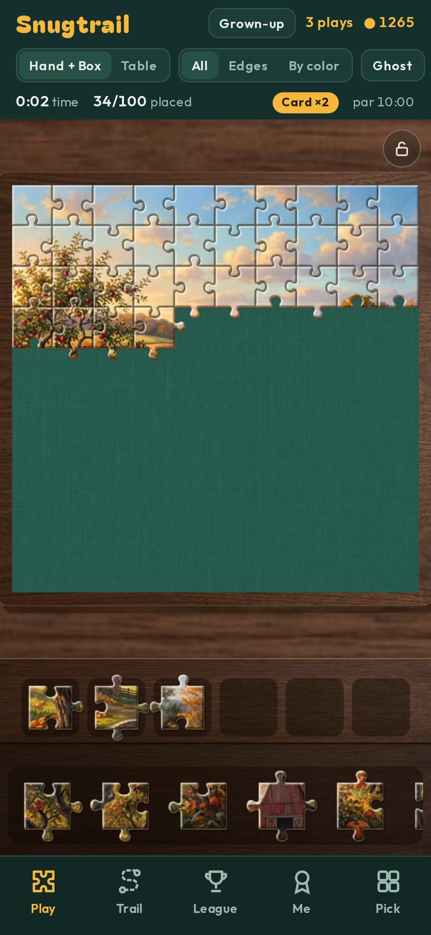 A Snugtrail puzzle in progress on a green felt mat, with loose pieces in the tray below